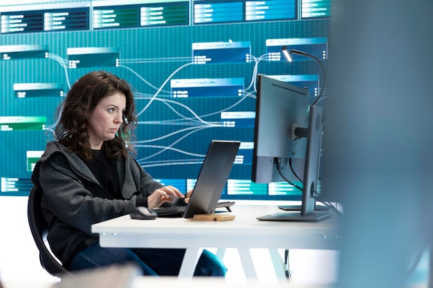 Female governmental hacker examines data on a computer in agency center
