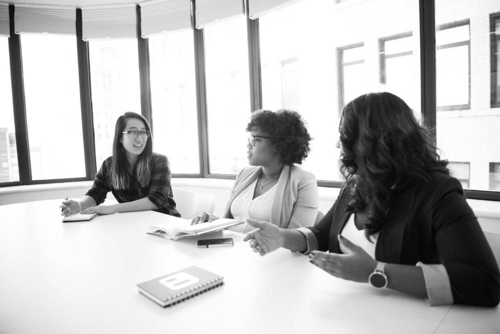 Monochrome photo of businesswomen engaged in a meeting.