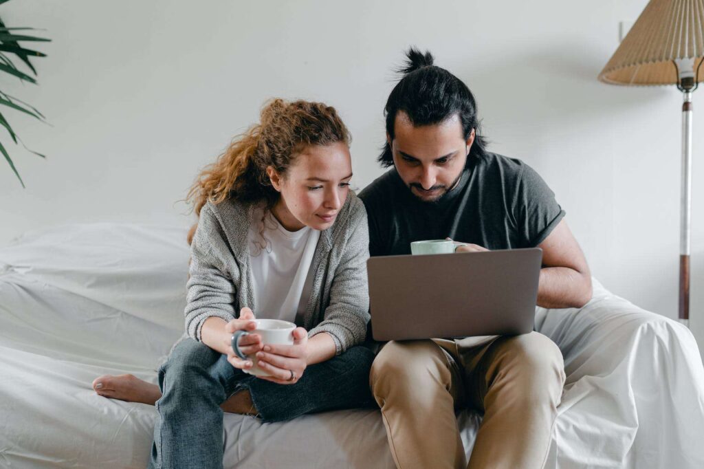 A man and woman observing a laptop with data encryption.