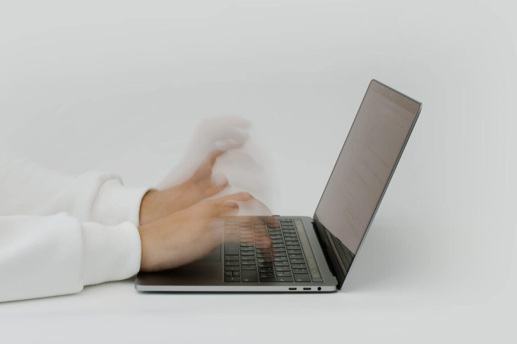 A person diligently types on a laptop computer, emphasizing the Importance of IT.